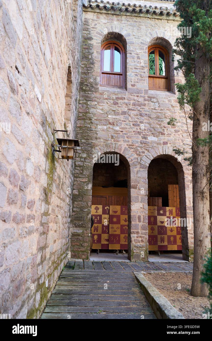 Alte Architektur zeigt ein Steingebäude mit gewölbten Türen, hölzernen Fenstern und dekorativem Stoff im Inneren. Diese alte Struktur vermittelt Geschichte Stockfoto