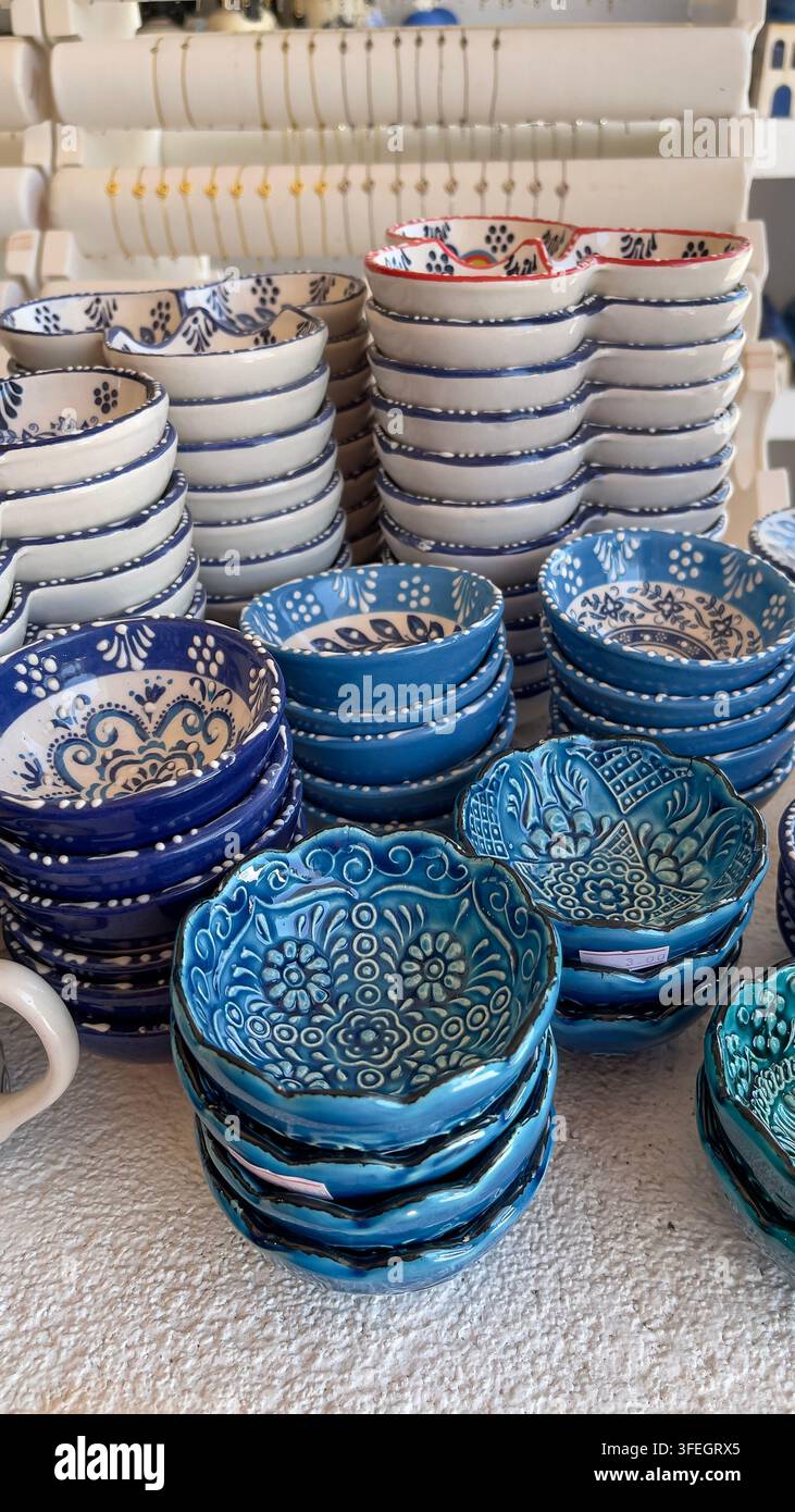 Blaue und weiße griechische Souvenirs Beschreibung: Bunte handgefertigte griechische Keramiksouvenirs mit Olivenmotiven, die traditionelle mediterrane Handwerkskunst präsentieren. - Smartphone-aufgenommenes Stockfoto