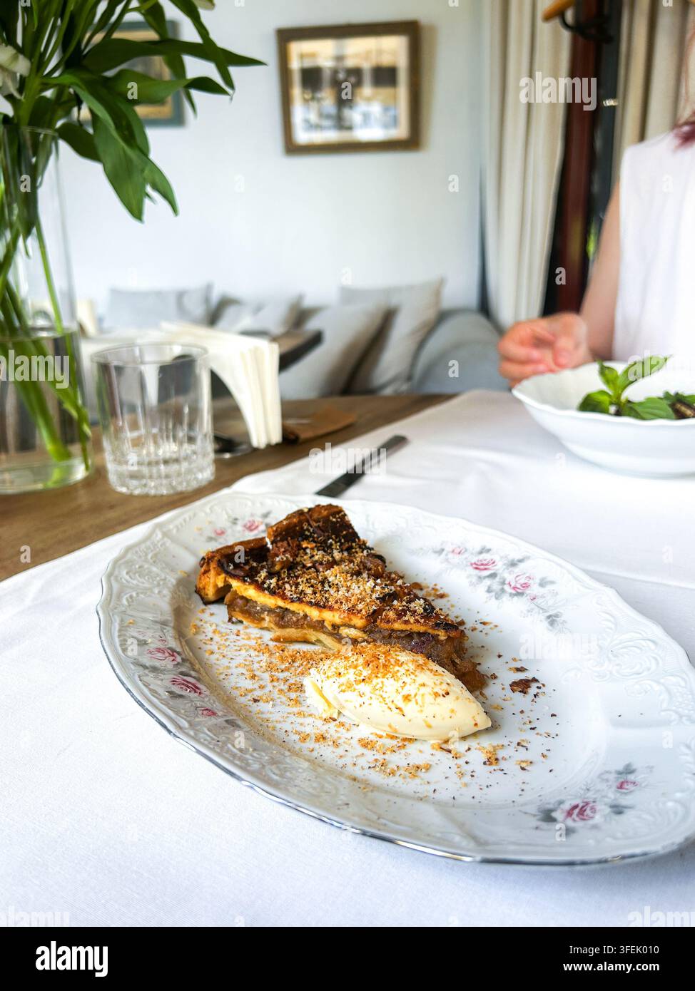 Apfelkuchen serviert auf Vintage-Teller mit Sauerrahm in einem Restaurant im Antik-Stil. Vertikal 4k Stockfoto