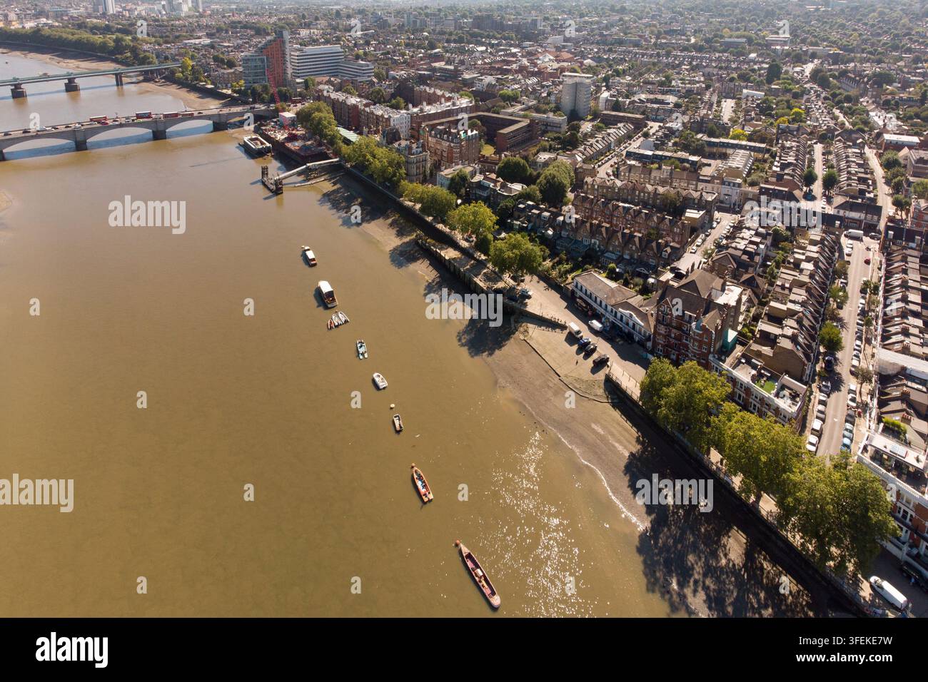 Eine Luftaufnahme von Booten, die an der Themse bei Putney Embankment und Bridge in Wandsworth, London, festgemacht sind, und die die städtische Uferpromenade zeigen. Stockfoto