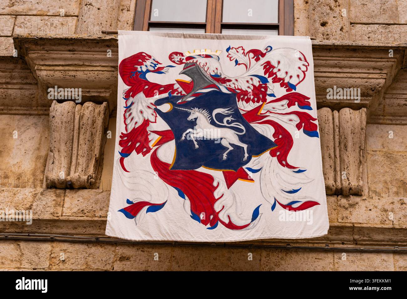 Heraldisches Banner mit Einhorn-Emblem an der Fassade eines historischen Gebäudes Stockfoto