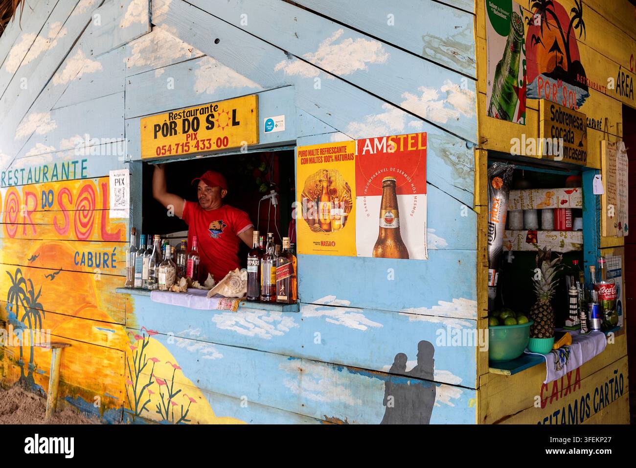 Ein lebhaftes farbenfrohes rustikales hölzernes lokales Restaurant, das mit Strandgemälden dekoriert ist, direkt am sandigen Ufer in der Nähe des Dorfes Atins in Brasilien. Stockfoto