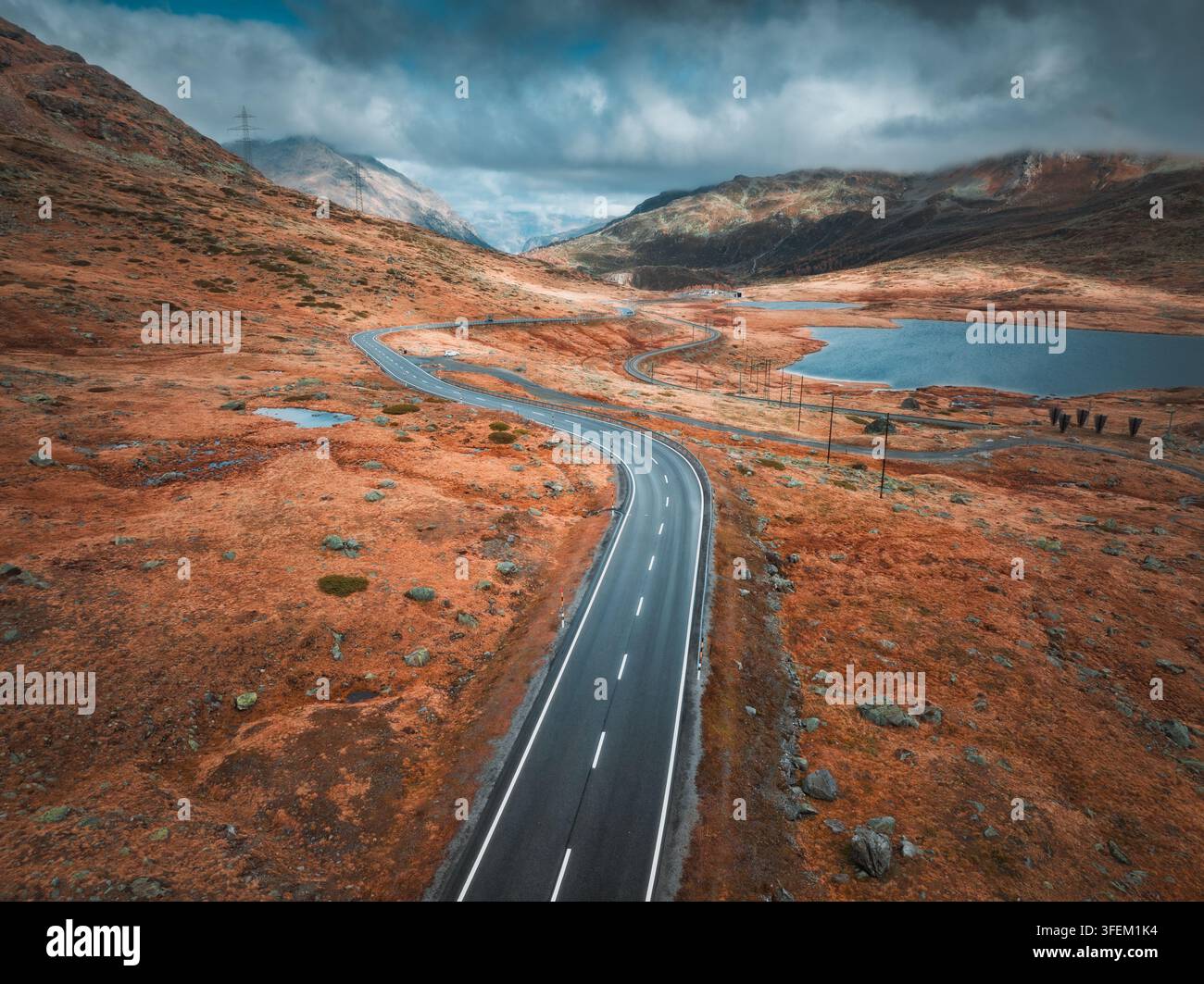 Drohnenansicht der nassen kurvenreichen Straße in den Schweizer Alpen Stockfoto
