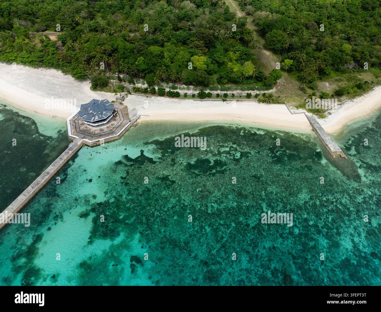 Rundes Gebäude, das durch einen Steg verbunden ist, steht auf sandigem Strand mit türkisfarbenem Meer und Korallenriff. Camotes, Philippinen. Stockfoto