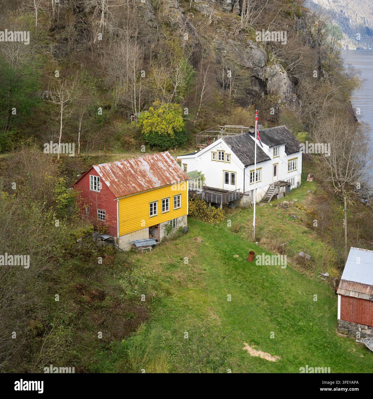 Historische norwegische Häuser stehen am Hardangerfjord in Ullensvang, Vestland, und zeigen das traditionelle ländliche Leben am Fjord. Stockfoto