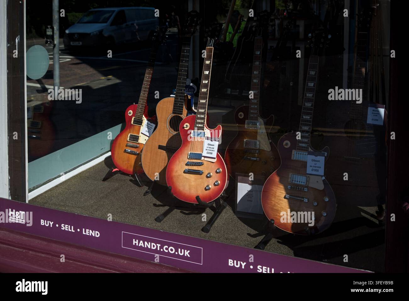 Gitarren zum Verkauf im Schaufenster eines Pfandleihhauses, Edinburgh, Schottland, UK. Stockfoto