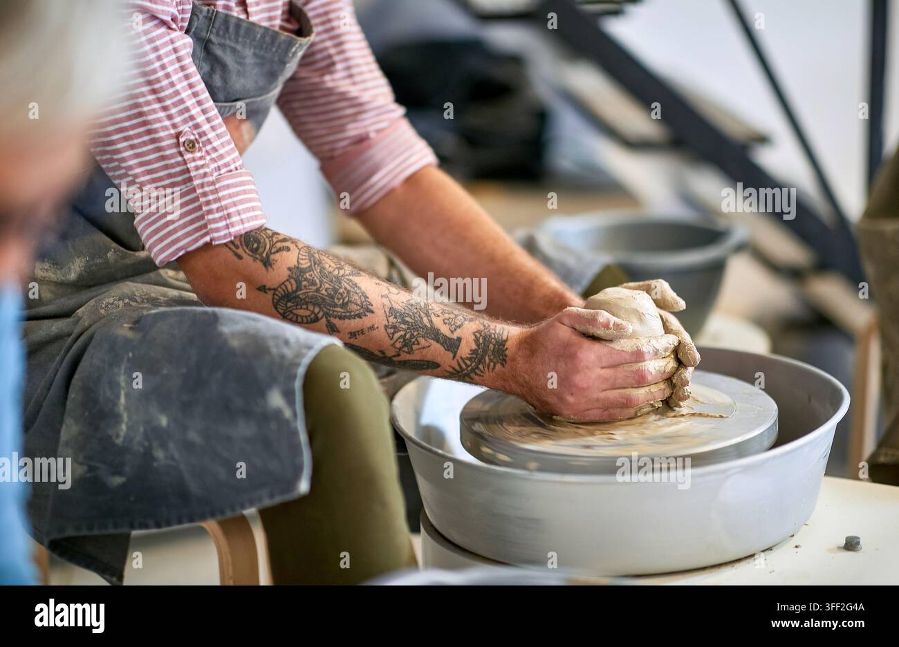 Nahaufnahme auf die Hand eines Mannes, der einen nassen Tontopf auf der Töpferscheibe formt. Kreatives Hobby, Aktivitätenkonzept Stockfoto