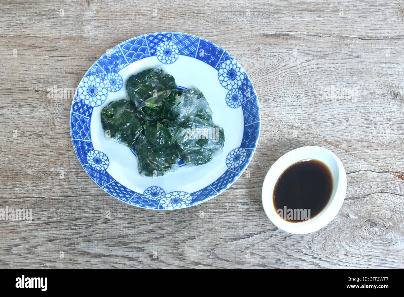 Backen von Guizhou-Dumpling mit gefüllter Knoblauchschote auf einem Teller, getaucht in scharfe schwarze Sojasauce Stockfoto