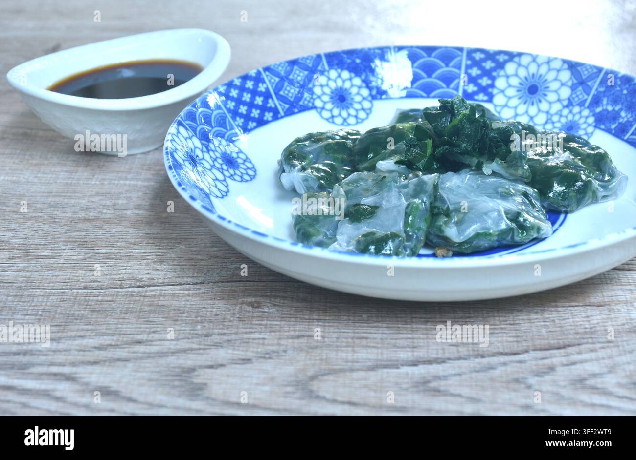 Backen von Guizhou-Dumpling mit gefüllter Knoblauchschote auf einem Teller, getaucht in scharfe schwarze Sojasauce Stockfoto