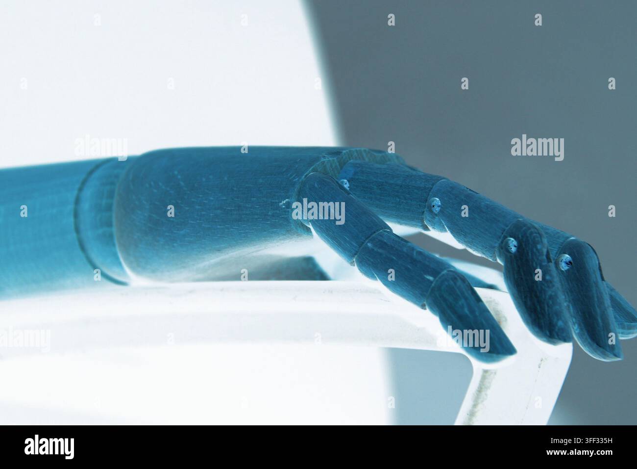 Nahaufnahme einer robotischen Hand, die auf der Armlehne eines Bürostuhls ruht und Technologie, künstliche Intelligenz, Maschinen, Arbeit, Geschäft und das f zeigt Stockfoto
