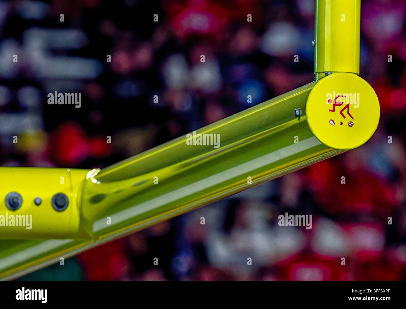 Eine hellgelbe Fußballtorstruktur auf einem American-Football-Feld, hervorgehoben durch eine kreisförmige Kappe mit einem dekorativen Grafikdesign am Gelenk Stockfoto