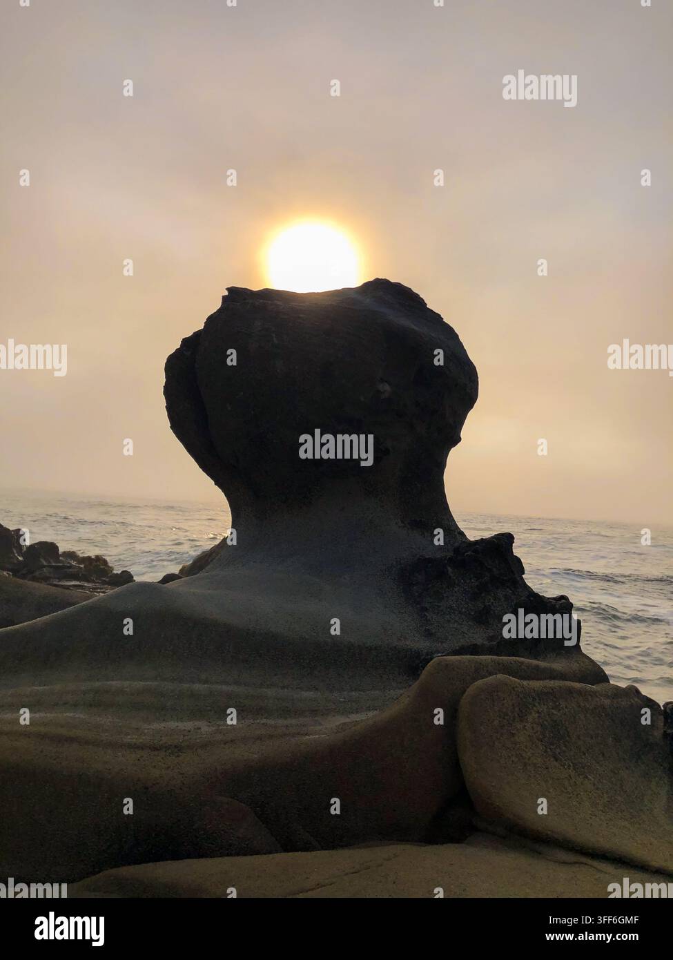 Silhouette einer einzigartigen Felsformation mit der untergehenden Sonne dahinter, gesehen von der Küste des Salt Point State Park, Kalifornien Stockfoto