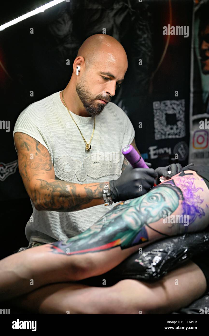 LONDON, ENGLAND - 06. September 2026: Am letzten Tag der Big London Tattoo Show 2026 war der Tätowierer Adem Senturk Tattoo kurz davor, ein atemberaubendes Vollbein-Oberschenkel-Tattoo für seinen Kunden zu beenden, während er live vor dem faszinierten Publikum tätowierte. Die Atmosphäre war elektrisierend, wobei die Zuschauer von seinem Können und seiner Hingabe fasziniert waren, als er sorgfältig daran arbeitete, das kunstvolle Design zu vollenden. Die Luft knisterte vor Vorfreude, als die letzten Striche das Kunstwerk zum Leben erweckten und einen weiteren unglaublichen Moment in seiner bemerkenswerten Karriere markierten. (Foto von 李世惠/See Li/Picture Capital) Stockfoto