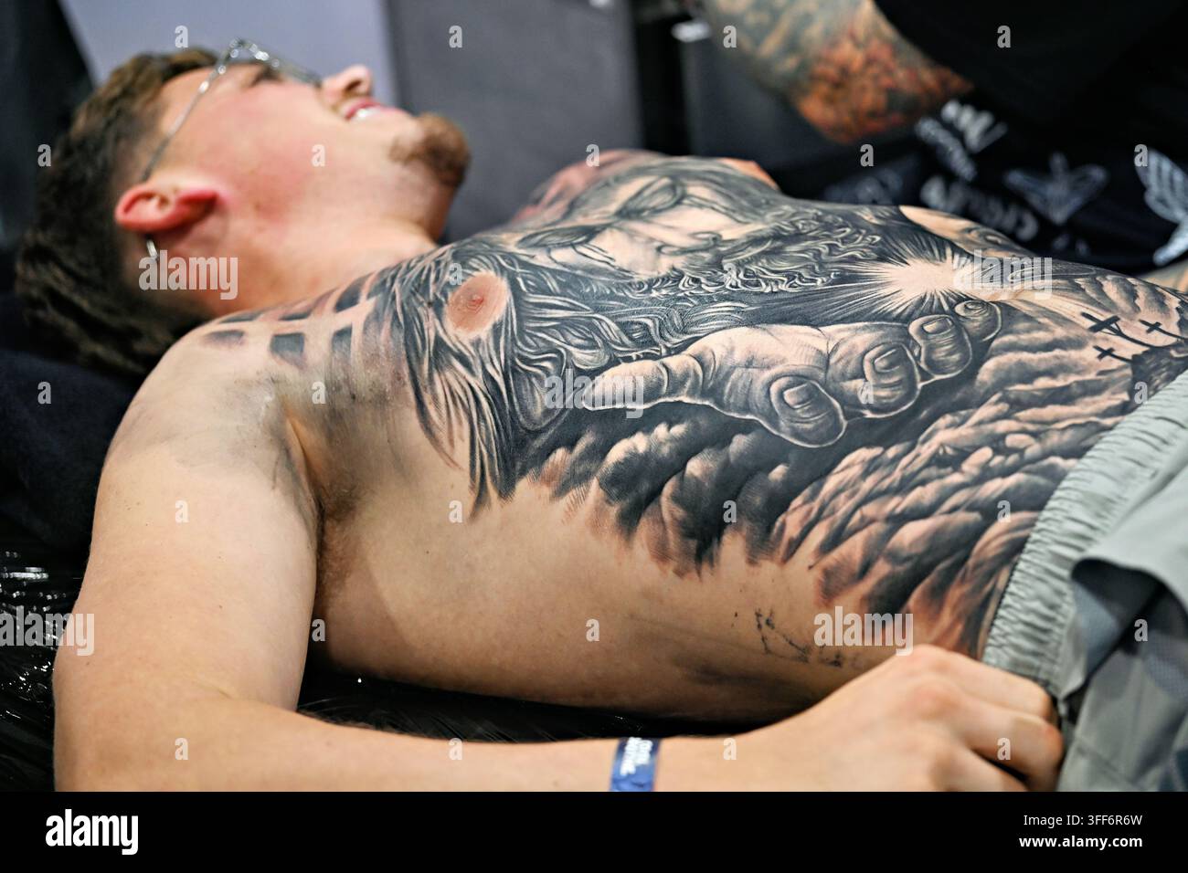 LONDON, UK. 06. Sep, 2026. Am letzten Tag der Big London Tattoo Show 2026 waren die Tätowierer von Diamond Heart Tattoo fast fertig mit einem Vollbrusttattoo, das sie live für ihren Kunden tätowierten. (Foto von 李世惠/See Li/Picture Capital) Credit: See Li/Picture Capital/Alamy Live News Stockfoto