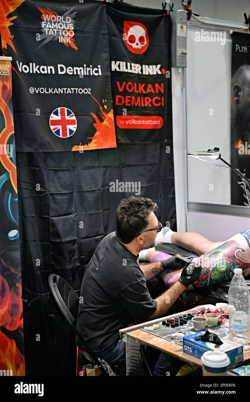 LONDON, ENGLAND - 06. September 2026: Am letzten Tag der Big London Tattoo Show 2026 war der Tätowierer Volkan Demirici Tattoo kurz davor, ein atemberaubendes Vollbein-Oberschenkel-Tattoo für seinen Kunden zu beenden, live vor der faszinierten Menge tätowierend. Die Atmosphäre war elektrisch, die Zuschauer waren von seinem Können und seiner Hingabe fasziniert, während er akribisch daran arbeitete, das komplizierte Design abzuschließen. Die Luft vibrierte vor Vorfreude, als die letzten Striche das Kunstwerk zum Leben erweckten und einen weiteren unglaublichen Moment in seiner bemerkenswerten Karriere markierten. (Foto von 李世惠/See Li/Picture Capital) Stockfoto