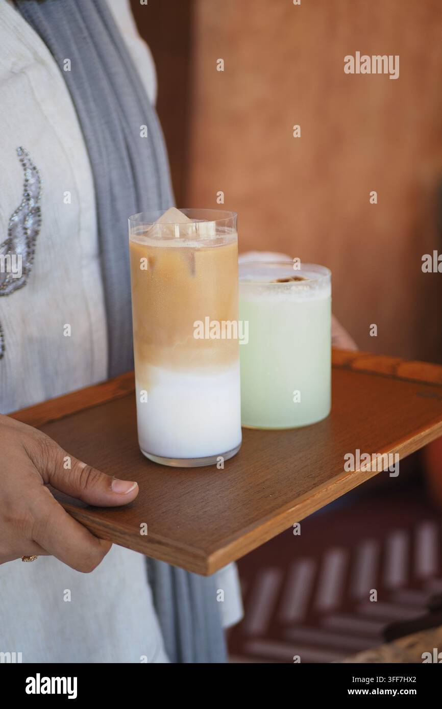 Ein Eiskaffee in einem hohen, klaren Glas auf einem Holzserviertablett Stockfoto