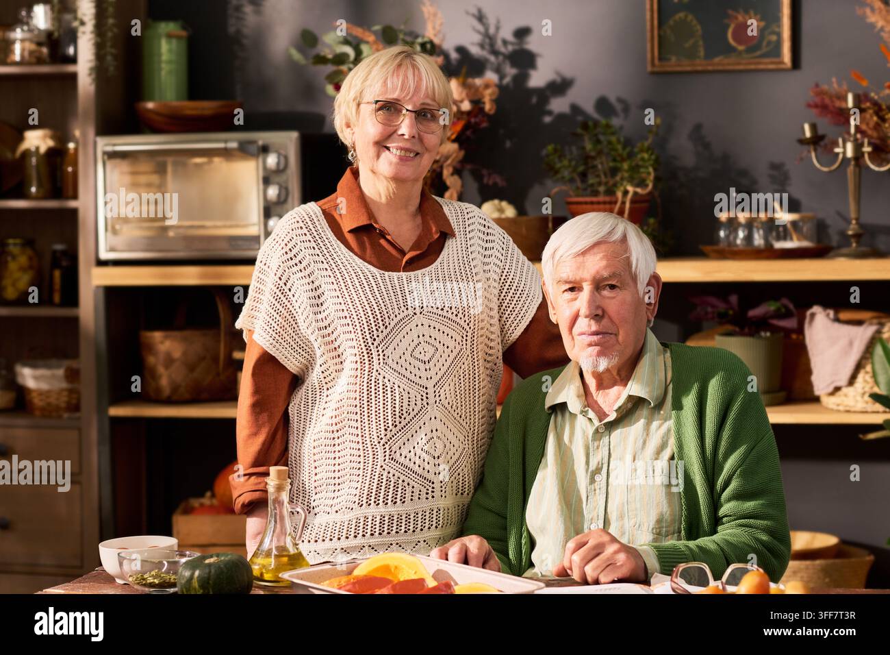 Porträt eines glücklichen Seniorenpaares, das in der Küche eine gesunde Mahlzeit zubereitet Stockfoto
