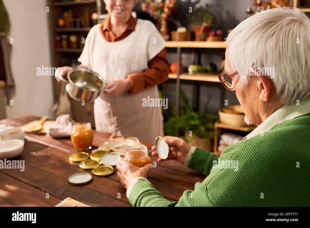 Seniorenpaar macht hausgemachte Konserven und Marmelade in der Küche Stockfoto