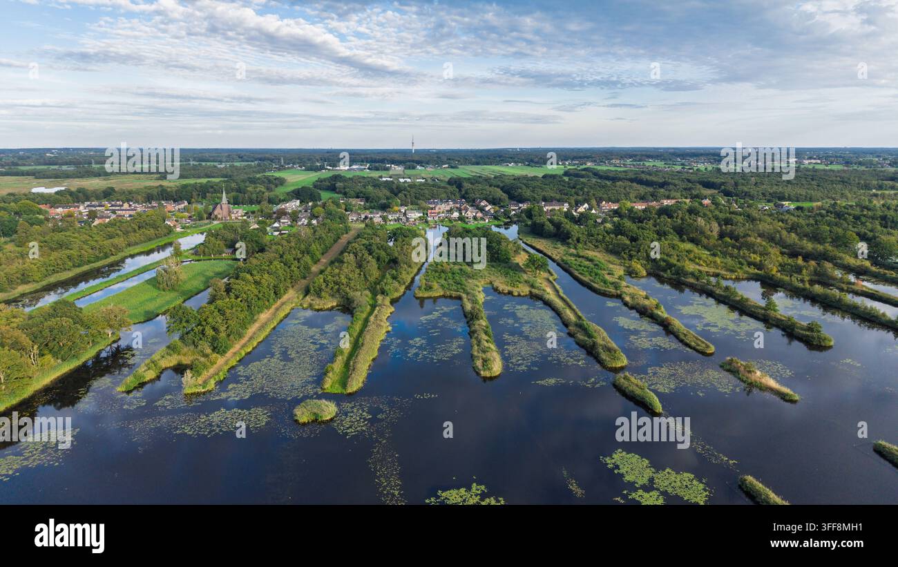 Luftaufnahme der Ankeveensche Plassen mit ihren charakteristischen Torfschneidestreifen, üppiger grüner Vegetation und dem Dorf Ankeveen im Hintergrund Stockfoto
