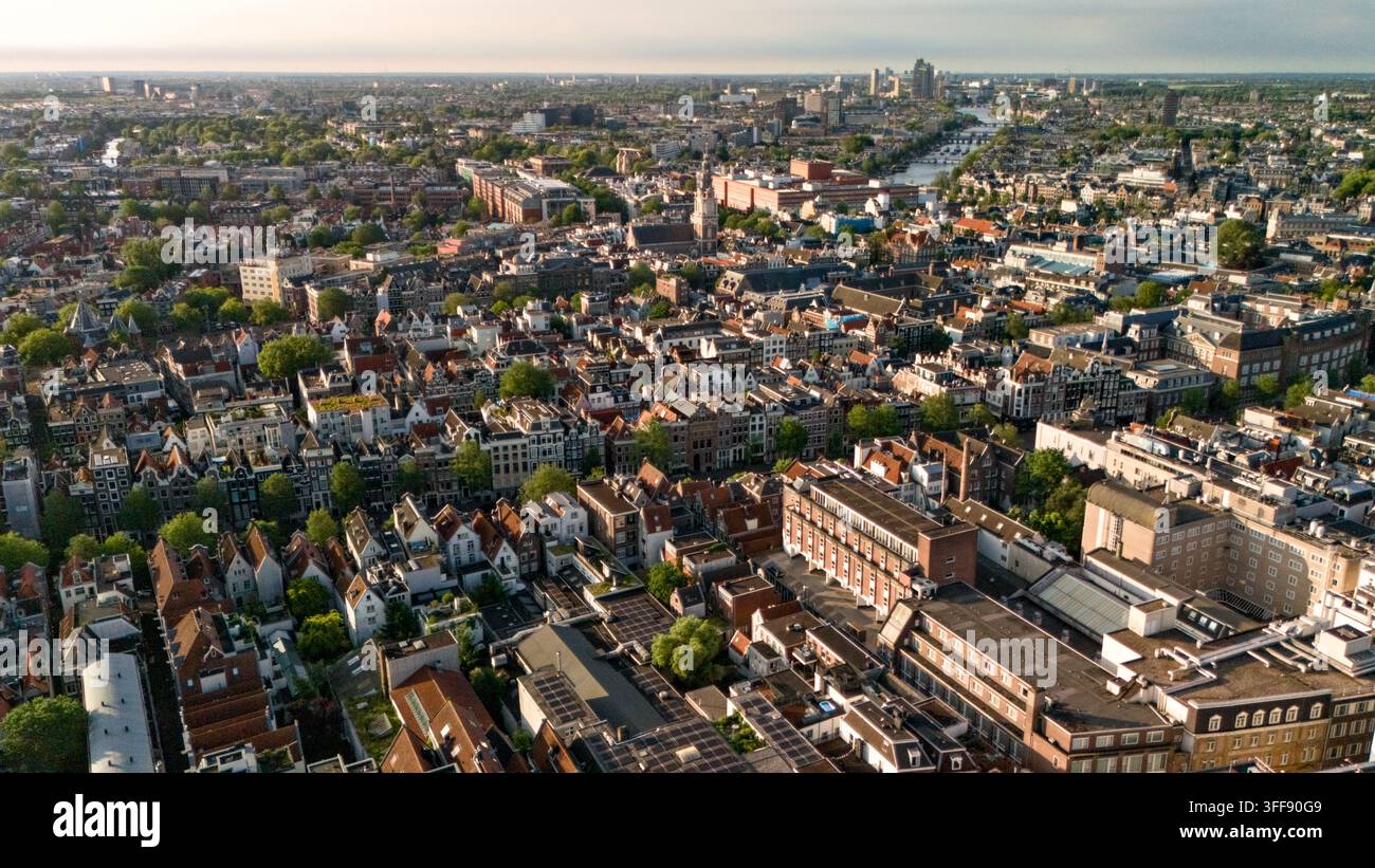 Luftbild von historischen Dächern und Wasserwegen mit der modernen Skyline im Hintergrund, Amsterdam, Niederlande. Stockfoto