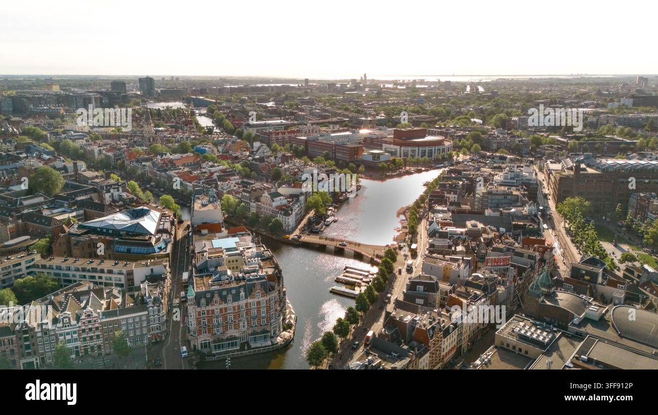 Luftaufnahme der Amstel, angrenzender Kanäle, Häuser, Brücken, Boote und der Skyline, Amsterdam, Niederlande. Stockfoto