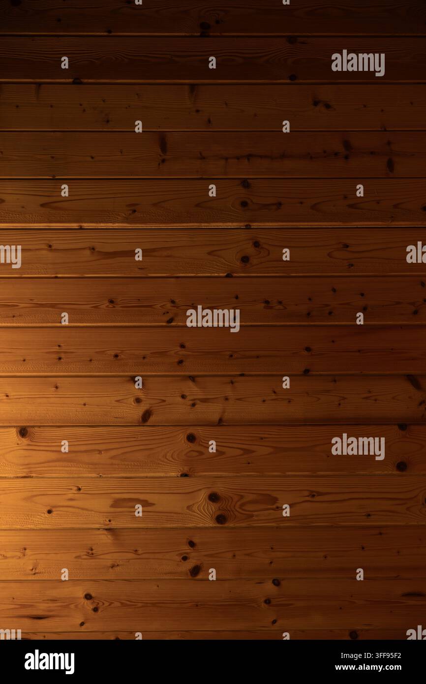 Interieur eines Raumes, der vollständig mit Zunge-und-Rillen-Holztäfelung verkleidet ist, mit horizontalen Brettern und warmem diffuses Licht, ein typischer Verkleidungsstil, der in Stockfoto