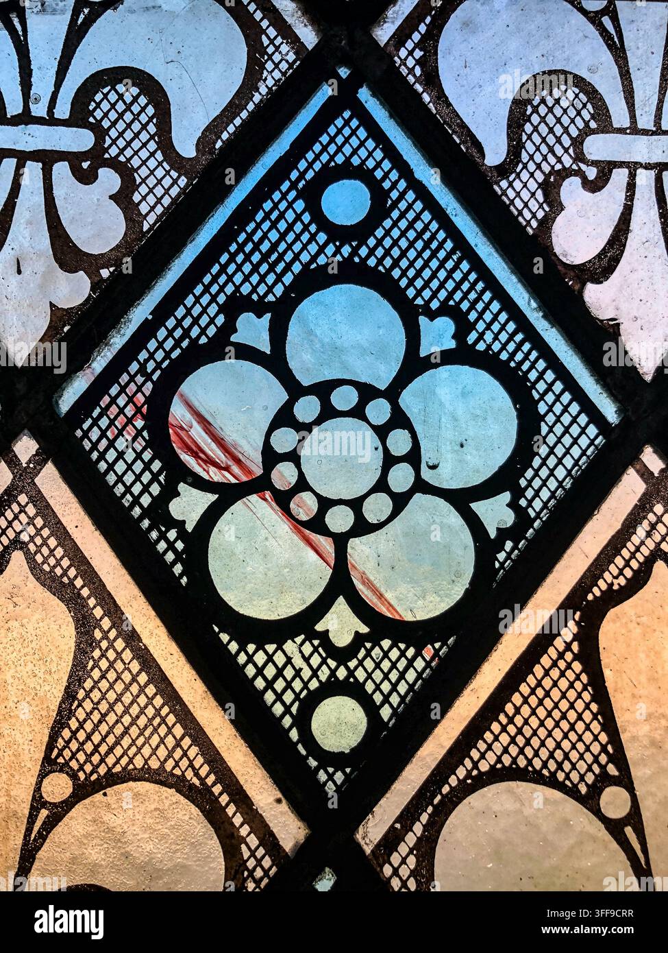 Nahaufnahme eines hellblauen Blumenmusters und geometrischer Bleiglasarbeiten in einem historischen Buntglasfenster in der Evans Memorial Chapel der University of Den Stockfoto
