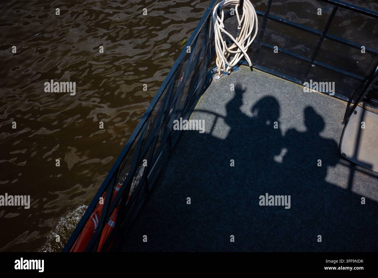 Schatten zweier Personen auf dem Deck während einer Flussbootfahrt, Gemeinschaft, langsames Reisen und gemeinsame Reise. Stockfoto