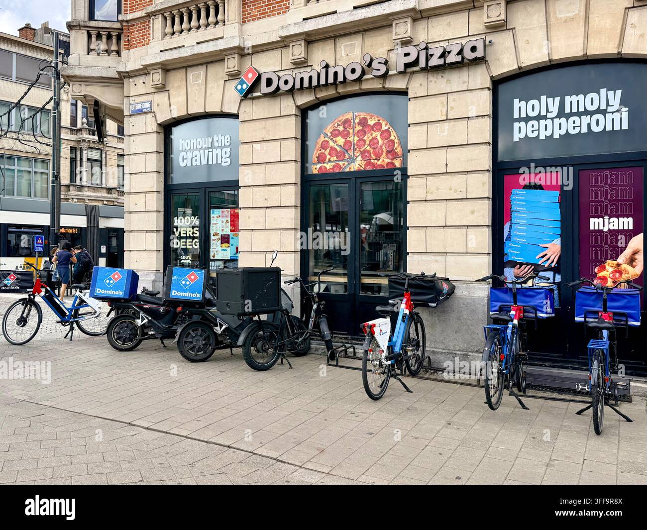 Domino's Pizza-Lieferfahrräder vor einer Filiale in Antwerpen, die die Globalisierung, multinationale Markenführung und die urbane Lieferwirtschaft in Belgien veranschaulichen Stockfoto