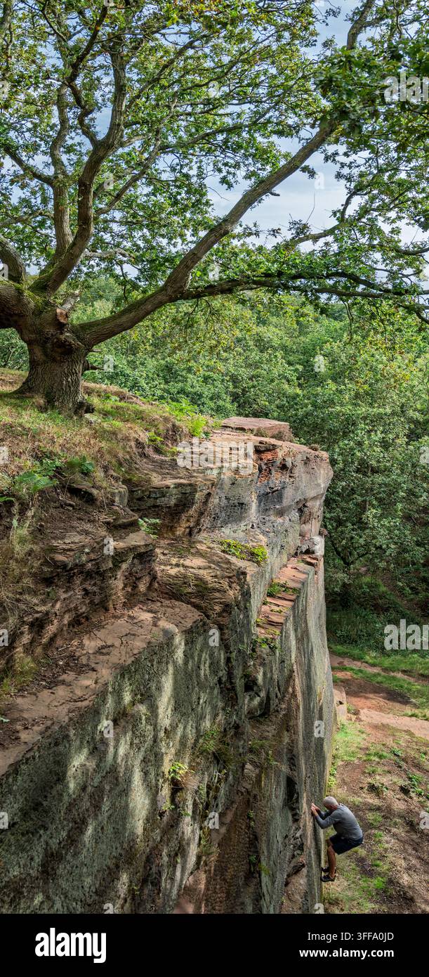 Ein Mann, der Klettern an einer Sandsteinklippe am Pex Hill in Widnes übt. Stockfoto