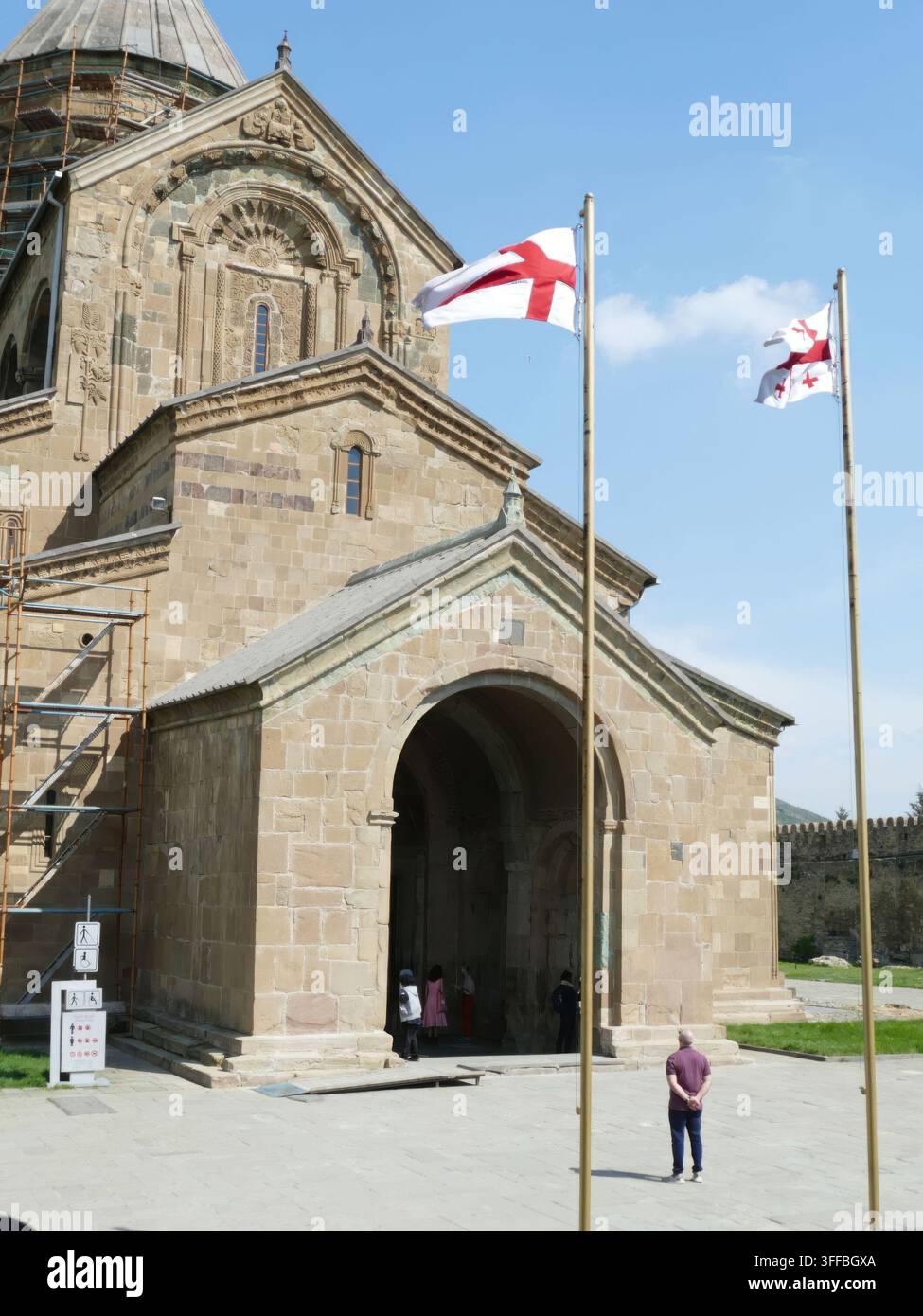 GEORGIEN, KAUKASUS - 27. APRIL 2024 - Svetitskhoveli-Kathedrale, ein UNESCO-Weltkulturerbe in Mtskheta, Georgien, mit georgischen Flaggen im Wind. Stockfoto