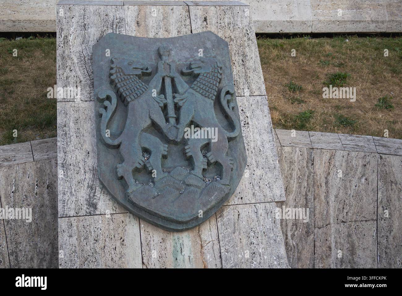 Dekoratives Metallschild mit gepaarten heraldischen Tieren auf einem Steinmonument - Cluj-Napoca, Rumänien - 15. August 2026 Stockfoto