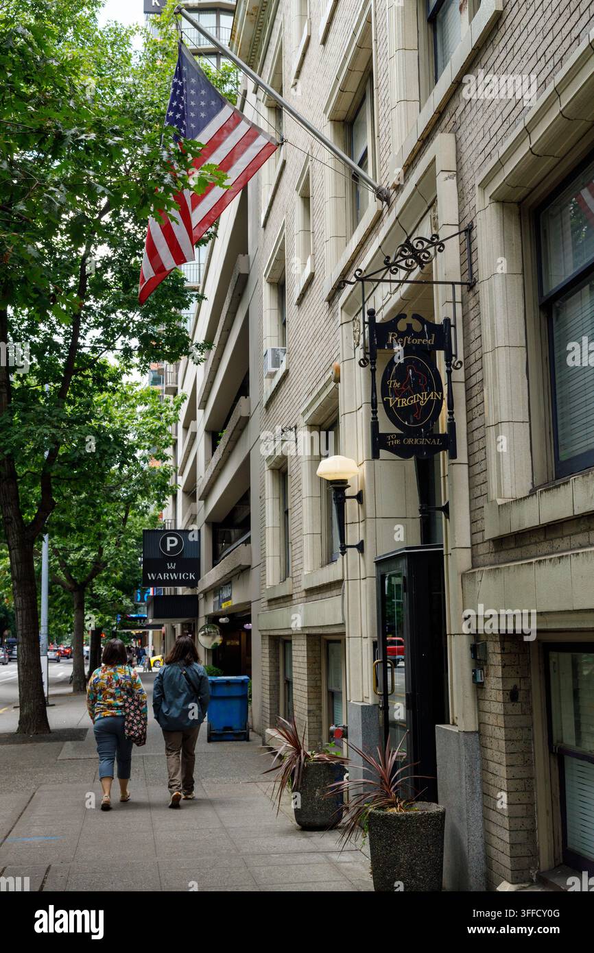 Seattle, USA – 29. August 2026: Ein kunstvoll gestaltetes hängendes Schild mit der Aufschrift „Restored, The Virginian, To The Original“, das an einem Backsteingebäude unter einem großen Ame angebracht ist Stockfoto