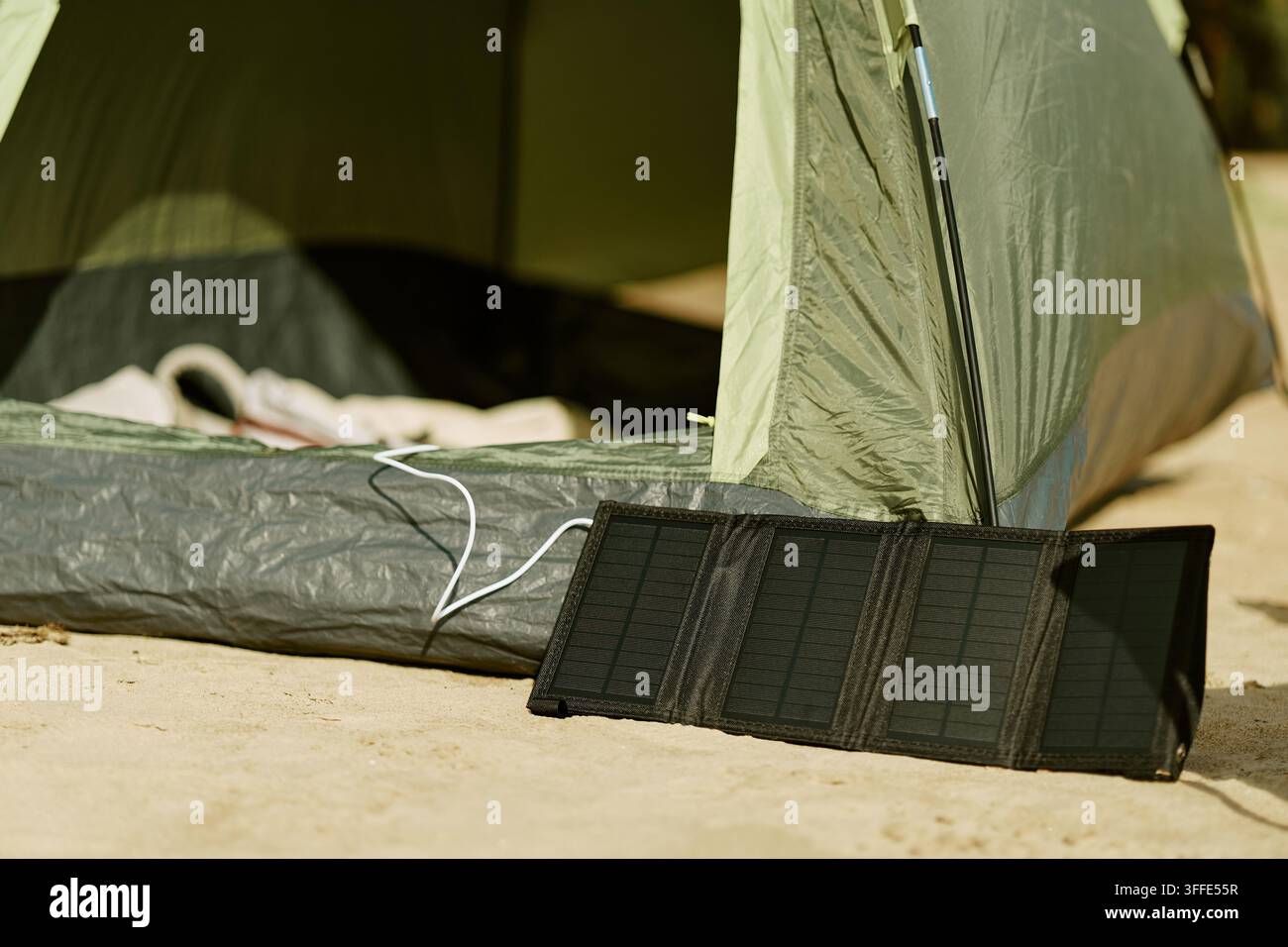 Tragbare Solarpanel-Ladegeräte neben dem Campingzelt Stockfoto