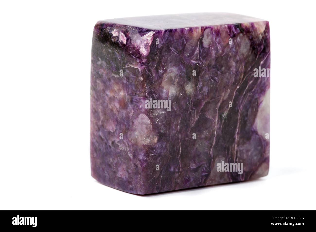 Makro-Mineralstein Charoit auf weißem Hintergrund im Nahaufnahme Stockfoto