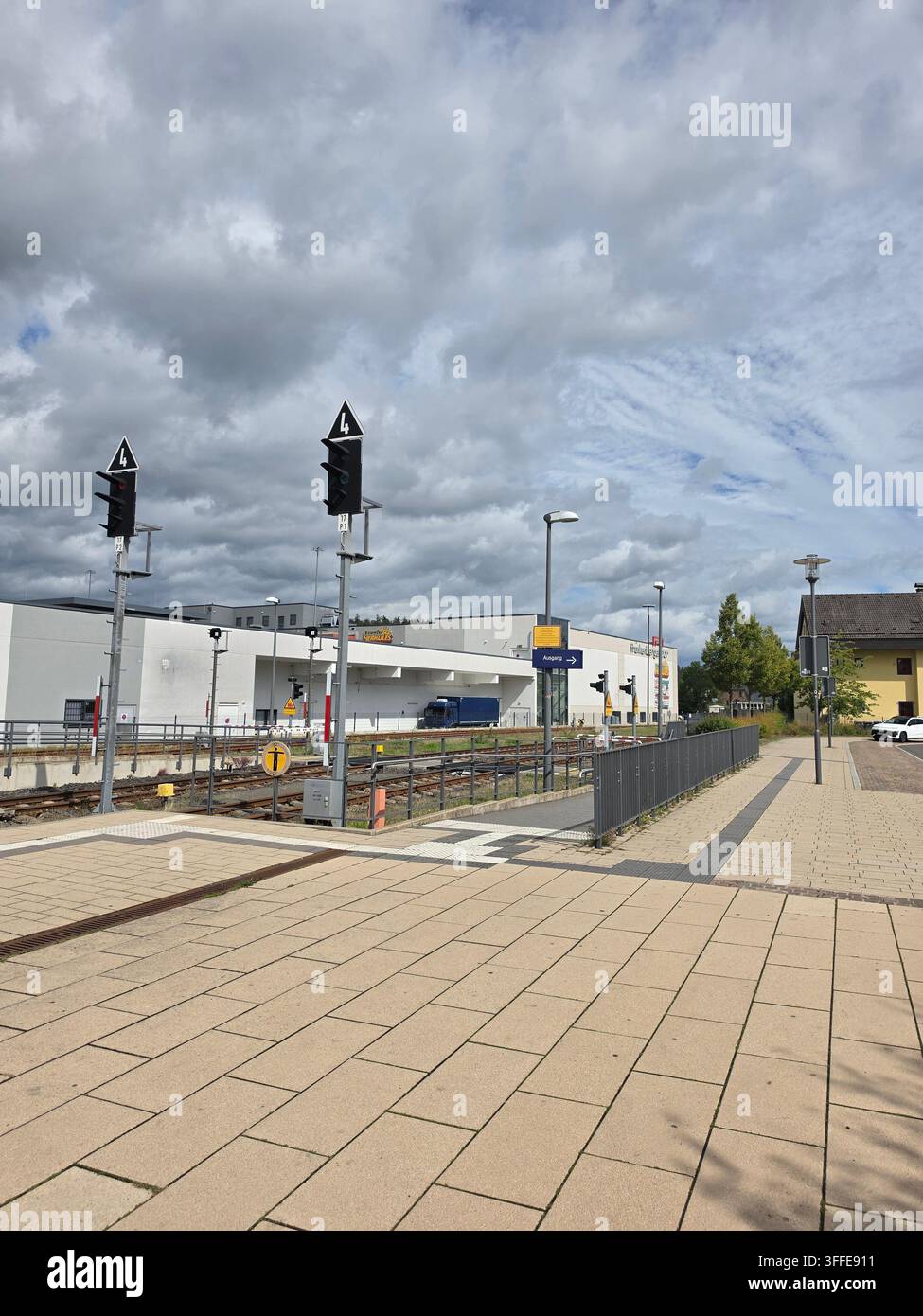 Leere Bahnsteigplattform eines Bahnhofs mit Ampeln und Infrastruktur an einem bewölkten Tag in Frankenberg, Hessen, Deutschland Stockfoto