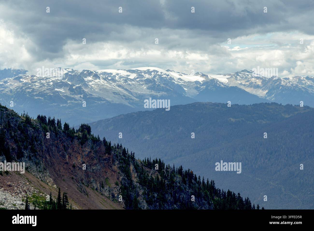 Mächtige Bergkette mit schneebedeckten Gipfeln unter einem bewölkten Himmel, Blackcomb-Gondel. Whistler, BC, Kanada Stockfoto