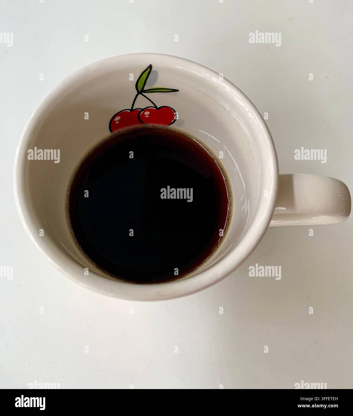 Kaffee in einer lustigen Tasse mit Kirschmuster Stockfoto
