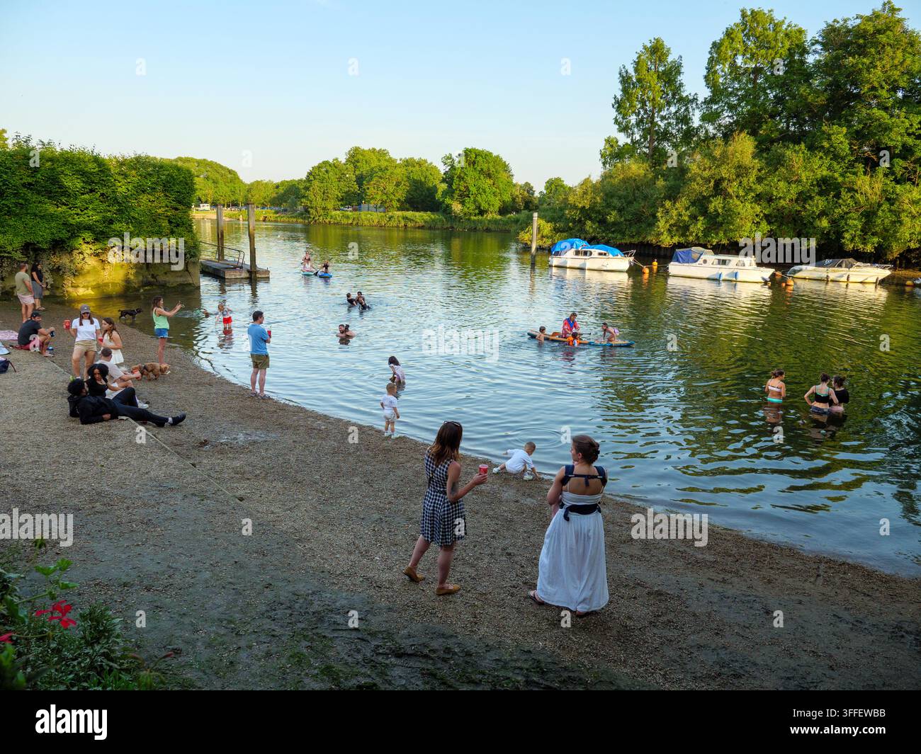 Menschen kühlen sich ab und spielen im Wasser der Themse in Twickenham, Richmond, London, UK Stockfoto
