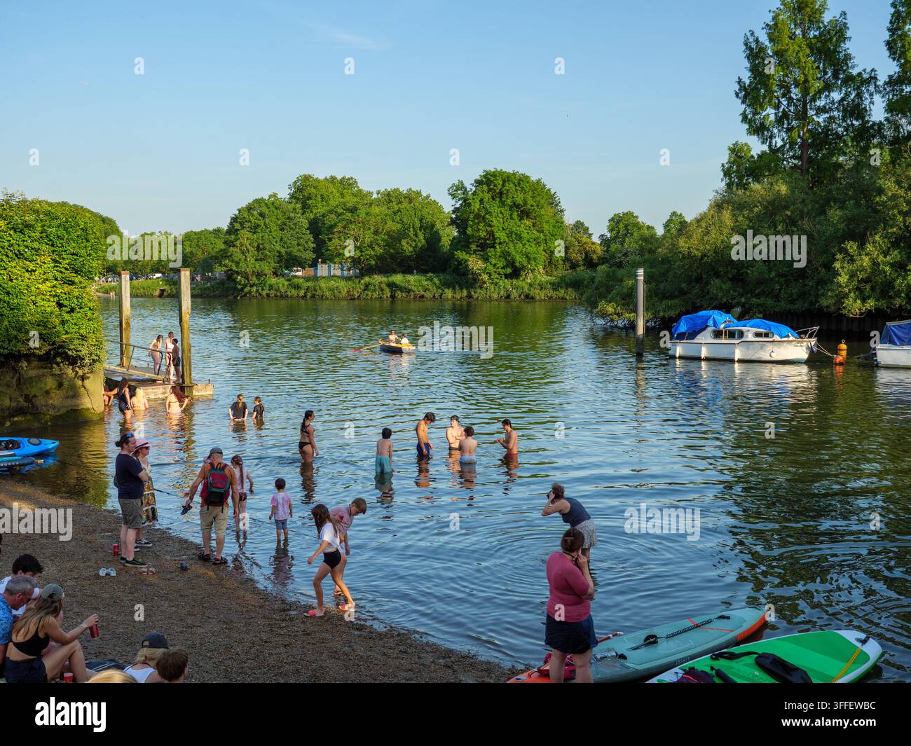 Menschen kühlen sich ab und spielen im Wasser der Themse in Twickenham, Richmond, London, UK Stockfoto