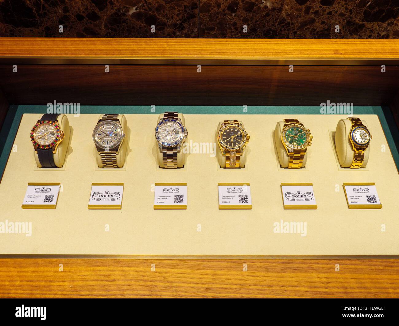 Teure Rolex-Uhren im Glaskasten des Ladens bei Harrods, London, UK Stockfoto