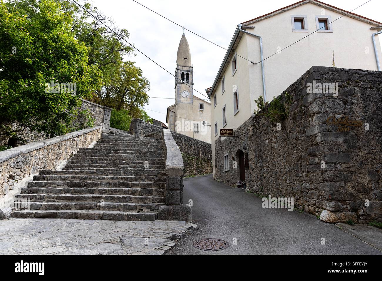 Schöne historische Steintreppe, die durch barocke Portale zum erhöhten Innenhof der St.-Daniel-Kirche im Dorf Stanjel hinaufführt Stockfoto