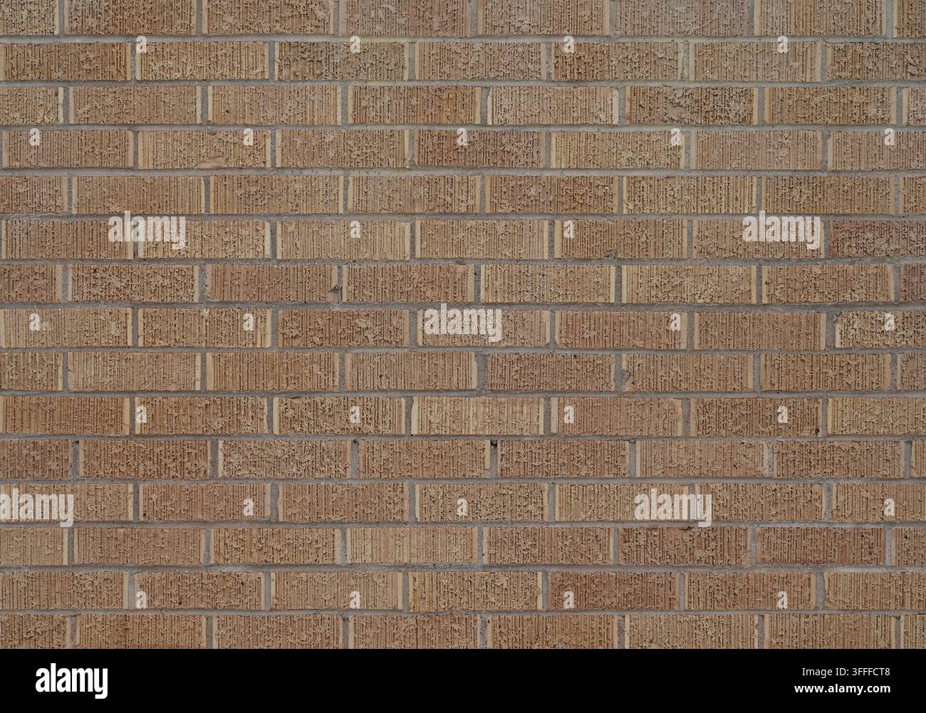 Nahaufnahme einer braunen, strukturierten Ziegelwand mit vertikal gerillten Ziegeln und verschiedenen braunen Ziegelvariationen Stockfoto