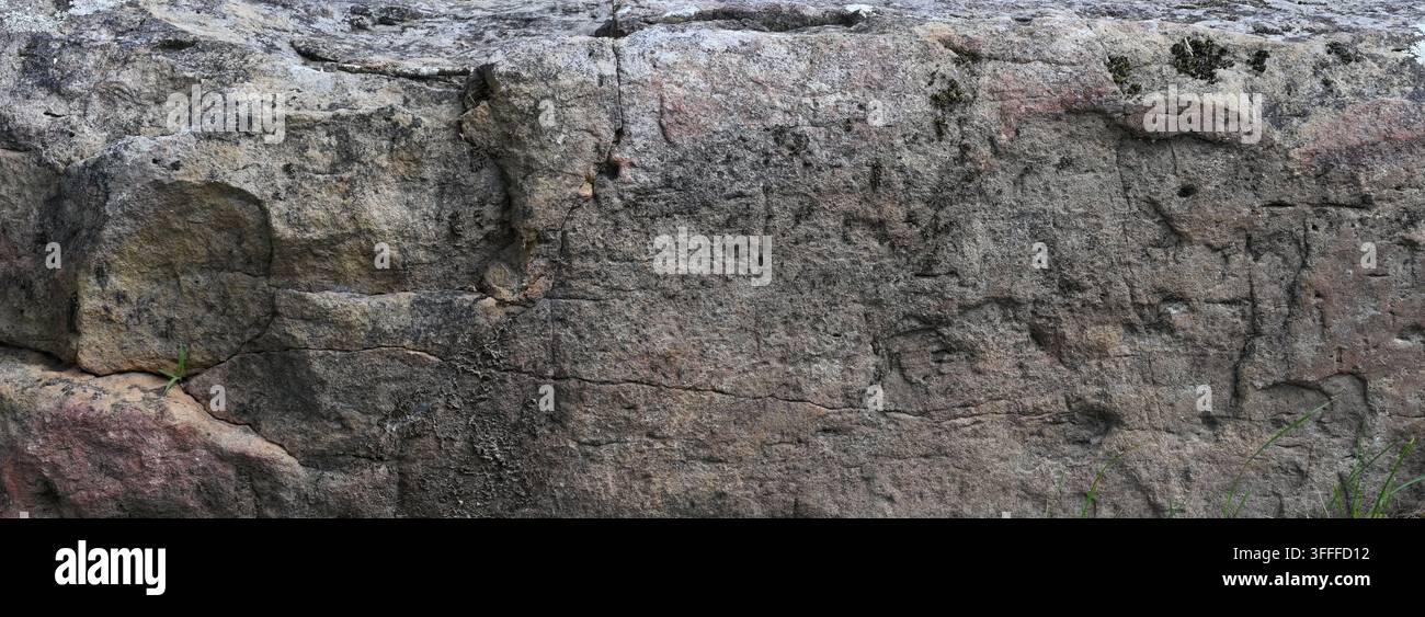 Verwitterte Steinbrockenoberfläche zeigt raue poröse Gesteinstextur, natürliche Steinmuster und geologische Oberflächendetails Stockfoto