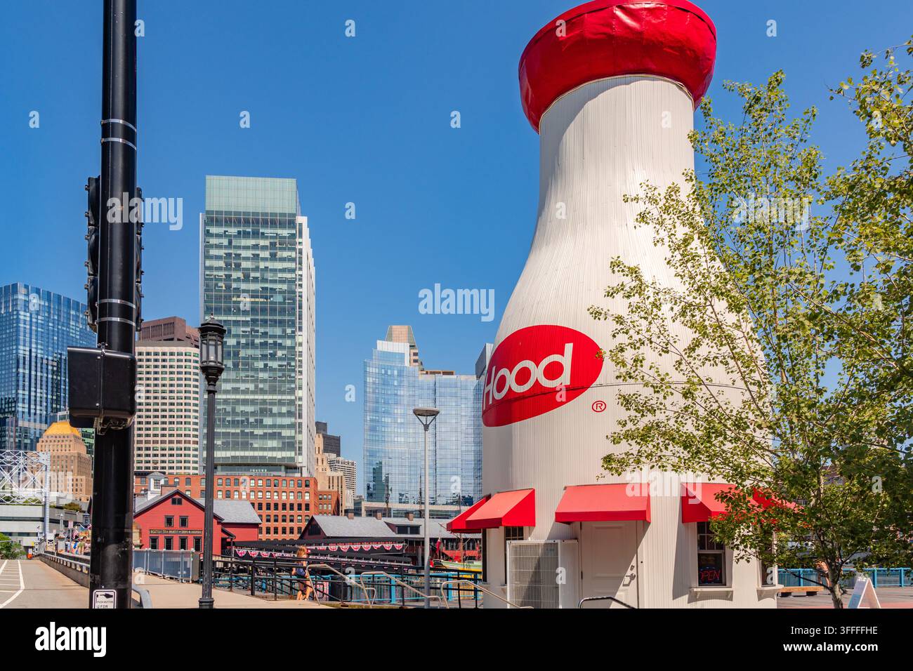 Boston, MA, USA – 11. Juli 2026: Die ikonische Hood-Milchflasche in South Boston im Seaport-Bezirk mit dem Fort Point Channel im Vordergrund und dem Boston Stockfoto
