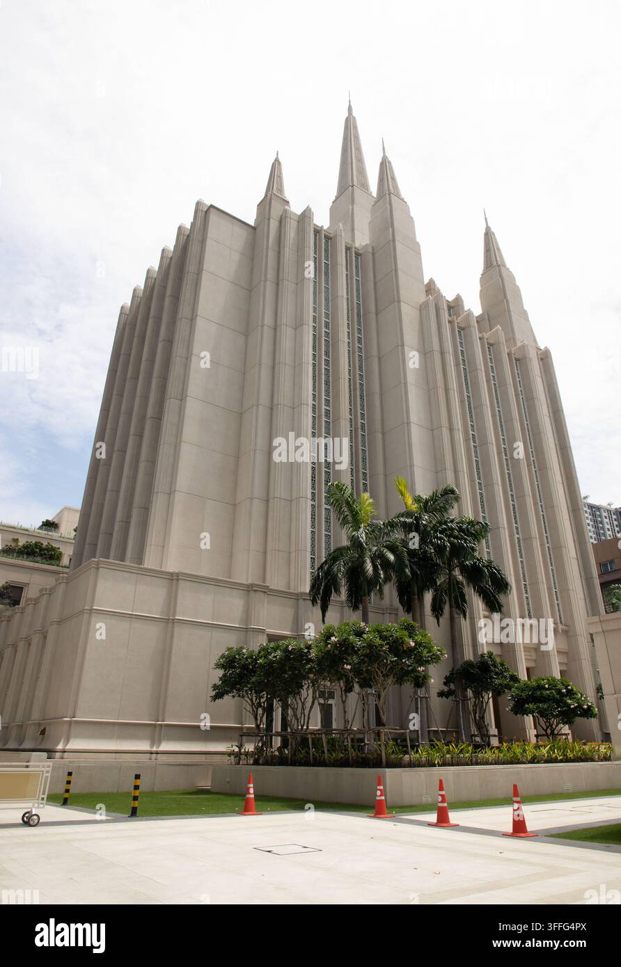 Bangkok, Thailand - 5. Sep, 2026 - Erhaben hinter einer Reihe lebendiger tropischer Palmen und gepflegter Grünflächen aufragend, die hoch aufragenden Steindächer der Stockfoto