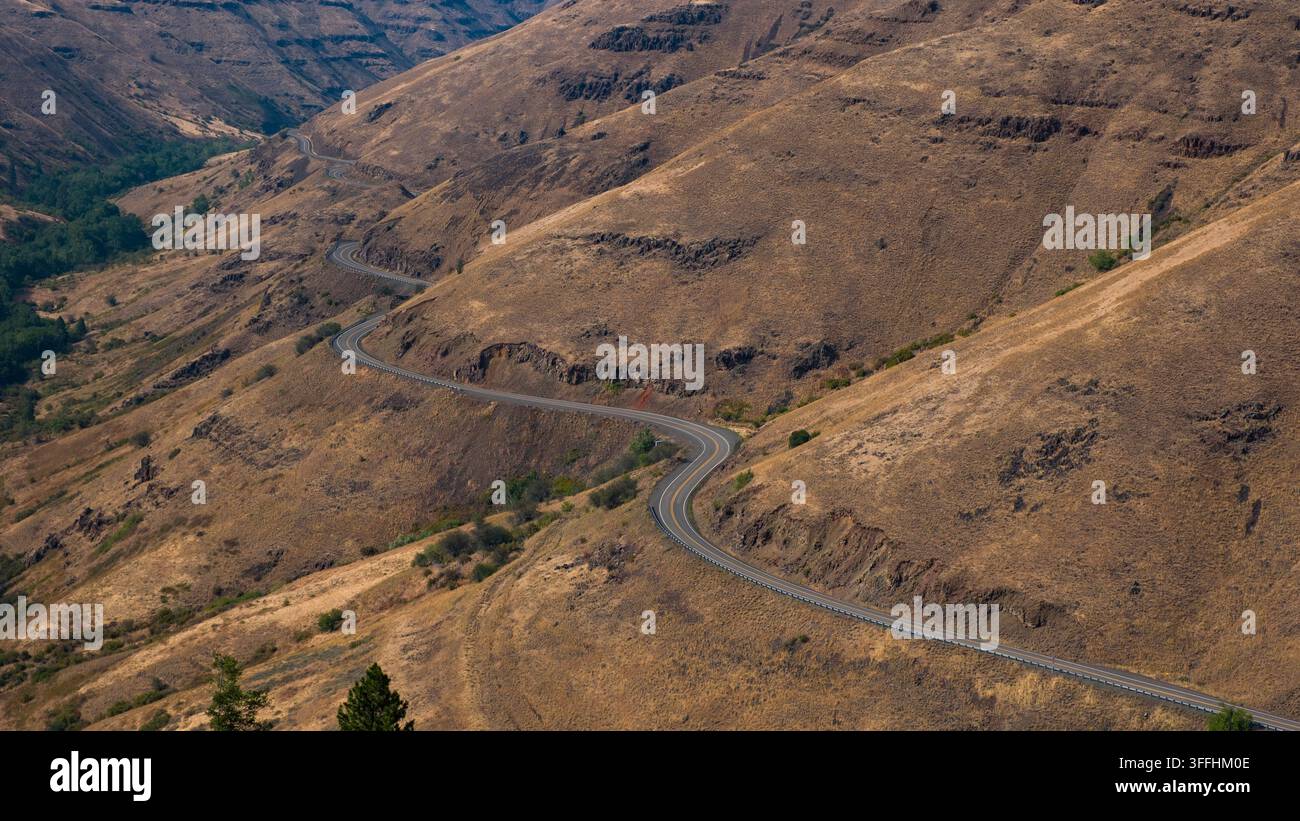 Die Lewiston Highway windet sich durch die dramatische Landschaft von Wallowa County, Oregon. Diese Route bietet Ausblicke auf weitläufige Täler und sanfte Hügel, showc Stockfoto