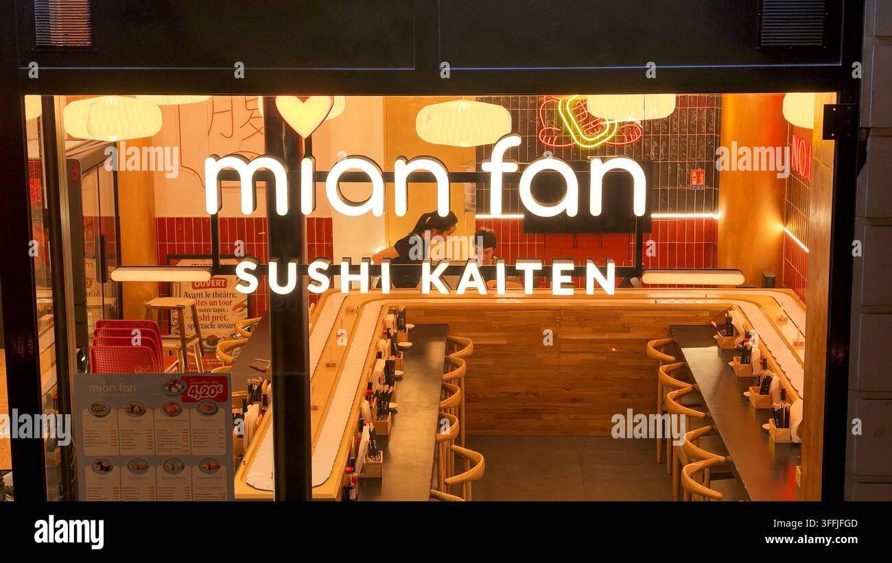 PARIS, FRANKREICH - 1. SEPTEMBER 2026 - Beleuchtetes Mian Fan Sushi-Kaiten-Restaurant mit Neonreklamen und leerer Theke in Paris Stockfoto