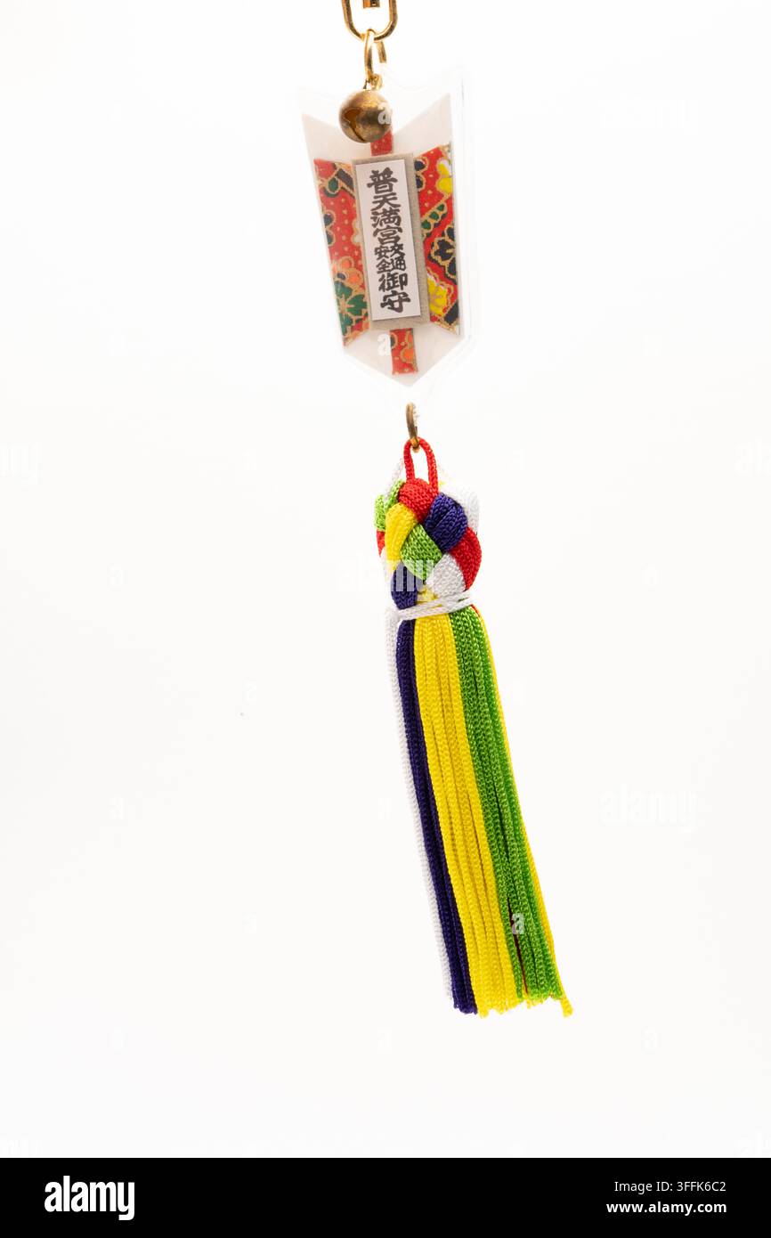 Ein japanisches Schutzamulett für sicheres Fahren (Omamori), das an einem Autofenster im Innenraum hängt. Stockfoto