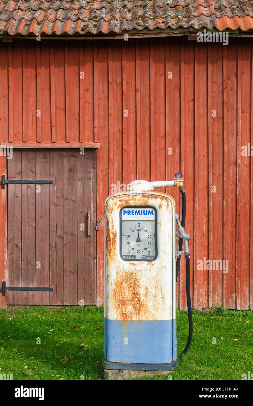 Alte, rostige Gaspumpe bei einer roten Scheune Stockfoto